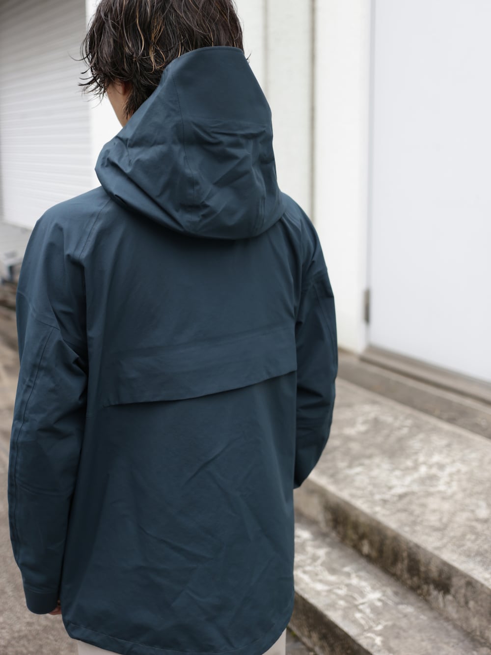 グリーン系のブルゾン、ベージュ系のスラックスを着用したメンズの秋コーディネートの5枚目の写真