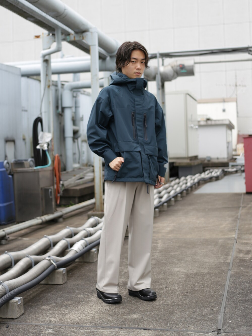 グリーン系のブルゾン、ベージュ系のスラックスを着用したメンズの秋コーディネートの2枚目の写真