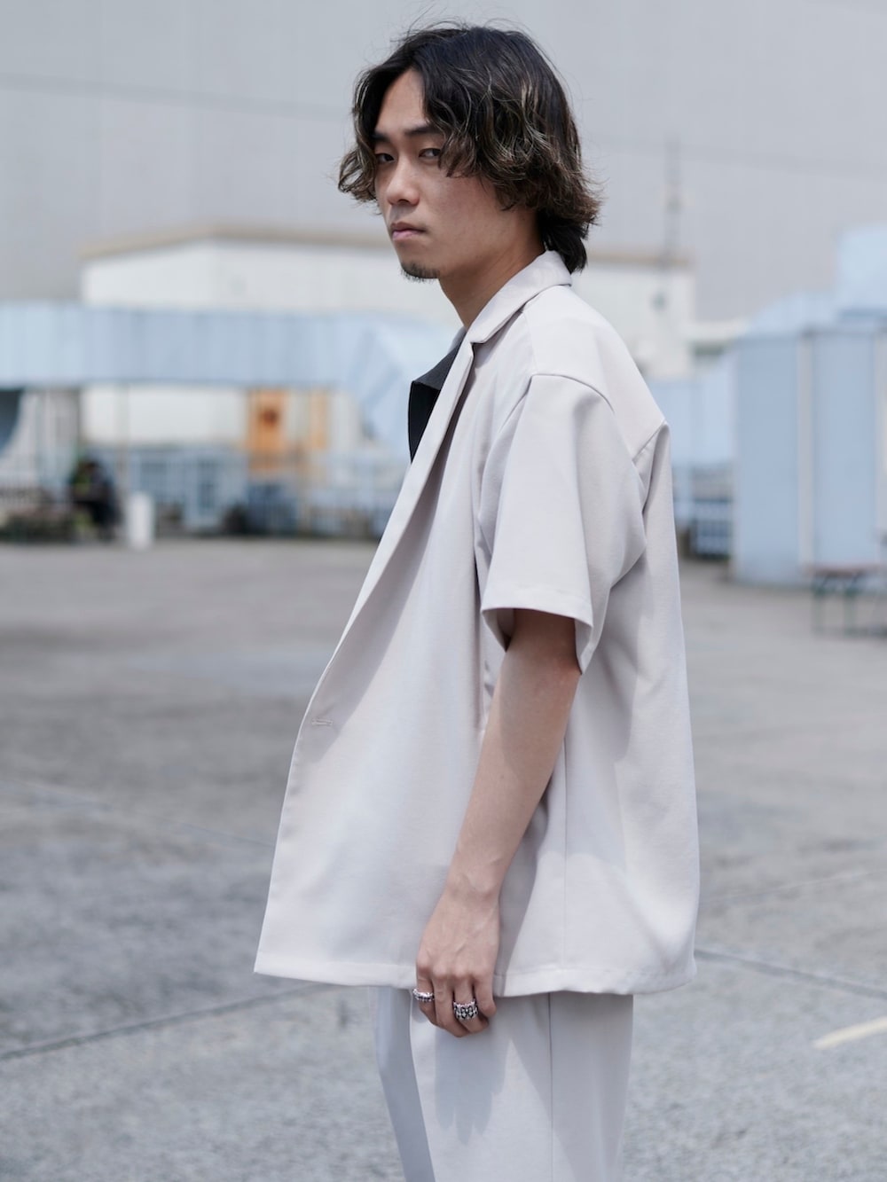 ホワイト系のテーラードジャケット、ホワイト系のスラックスを着用したメンズの春コーディネートの2枚目の写真