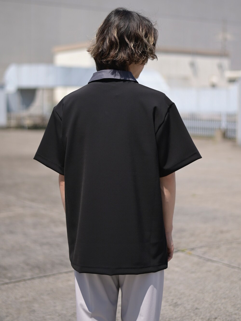 ブラック系のポロシャツを着用したメンズの春コーディネートの4枚目の写真