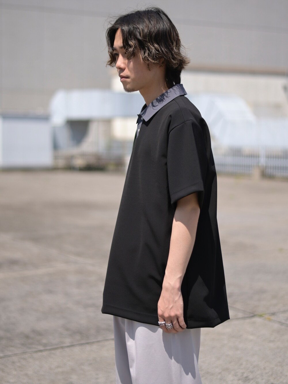 ブラック系のポロシャツを着用したメンズの春コーディネートの3枚目の写真