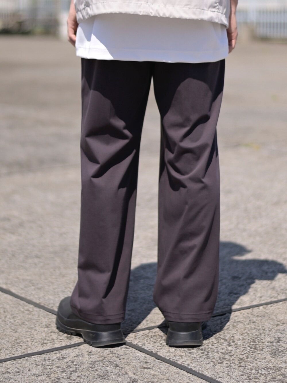 ホワイト系のTシャツ/カットソー、ブラウン系のスラックスを着用したメンズの春コーディネートの5枚目の写真