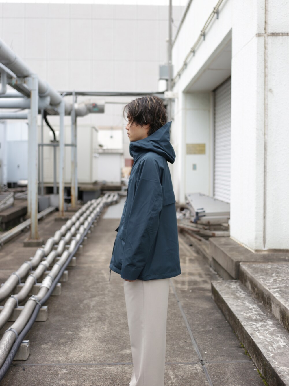 グリーン系のブルゾン、ベージュ系のスラックスを着用したメンズの秋コーディネートの4枚目の写真