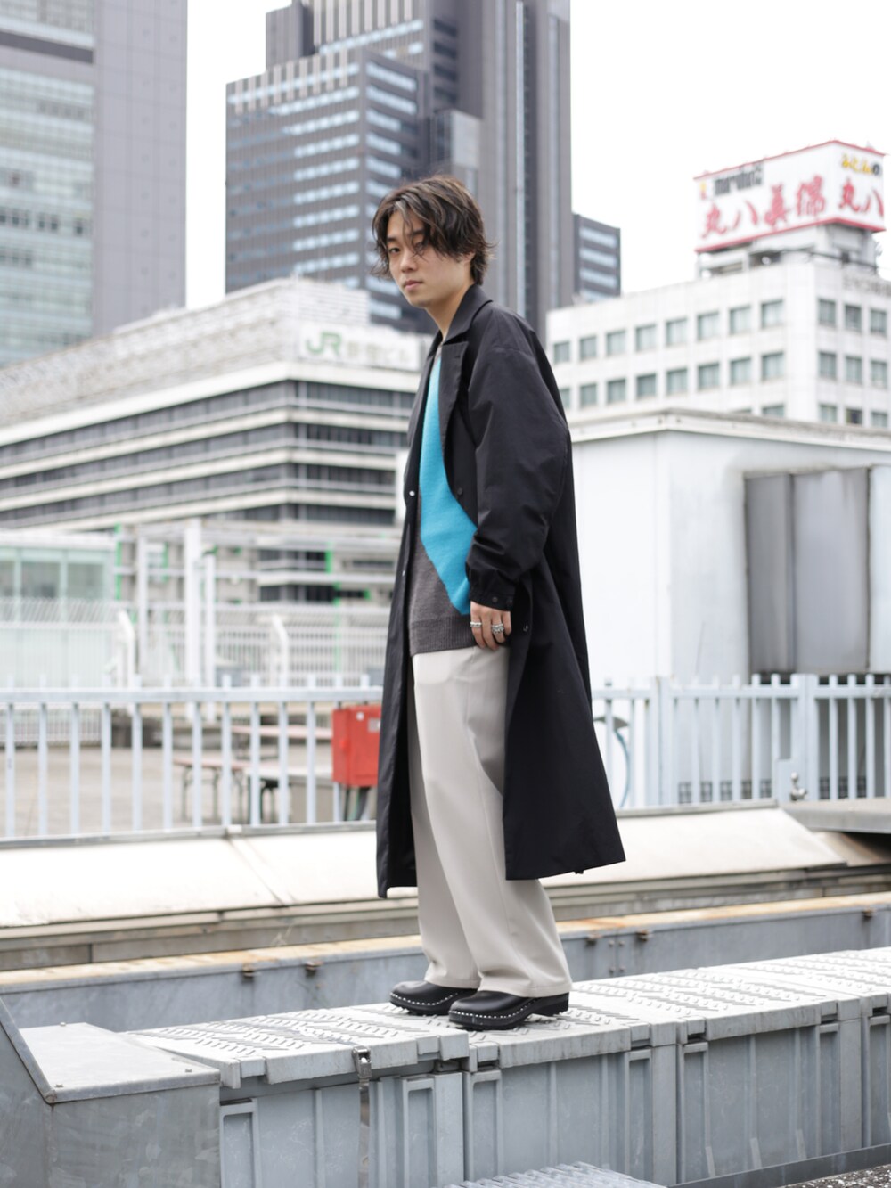 ブラック系のチェスターコートを着用したメンズの秋コーディネートの3枚目の写真