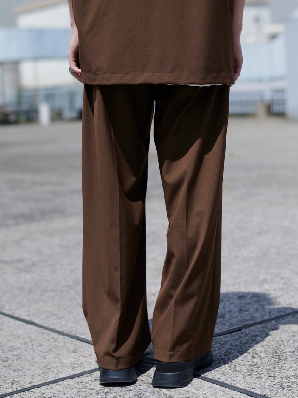 ブラウン系のスラックスを着用したメンズの春コーディネートの5枚目の写真