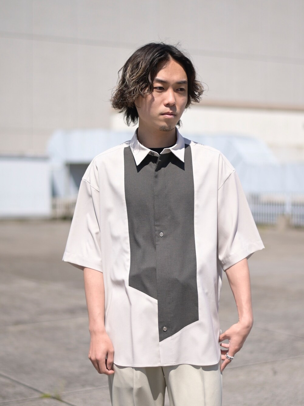 ベージュ系のスラックスを着用したメンズの夏コーディネートの2枚目の写真