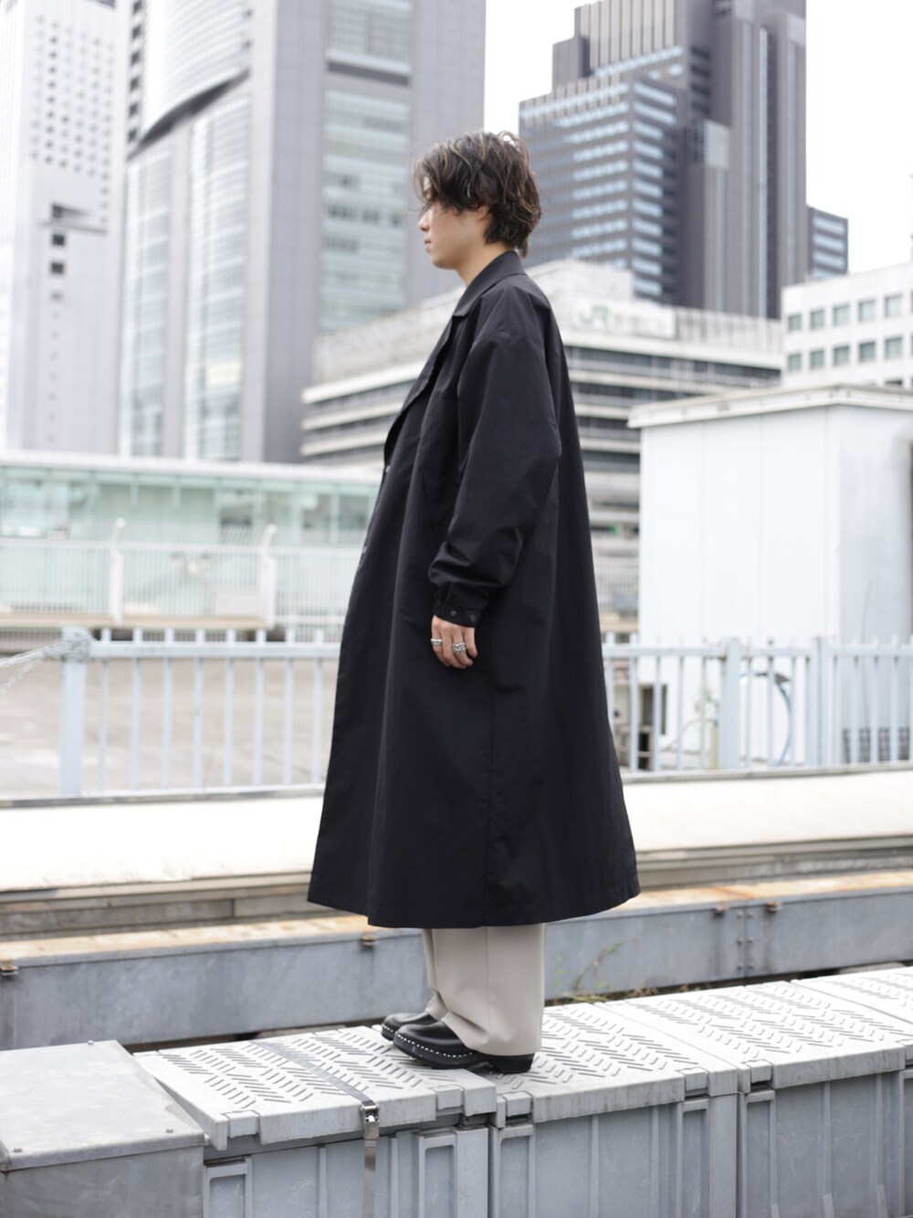 ブラック系のチェスターコートを着用したメンズの秋コーディネートの5枚目の写真