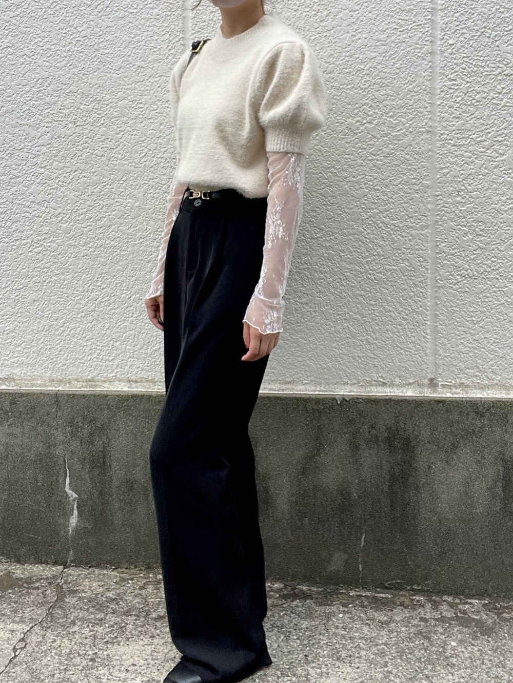 ホワイト系のニット/セーター、ホワイト系のシャツ/ブラウス、ブラック系のスラックスを着用したレディースの秋コーディネートの2枚目の写真