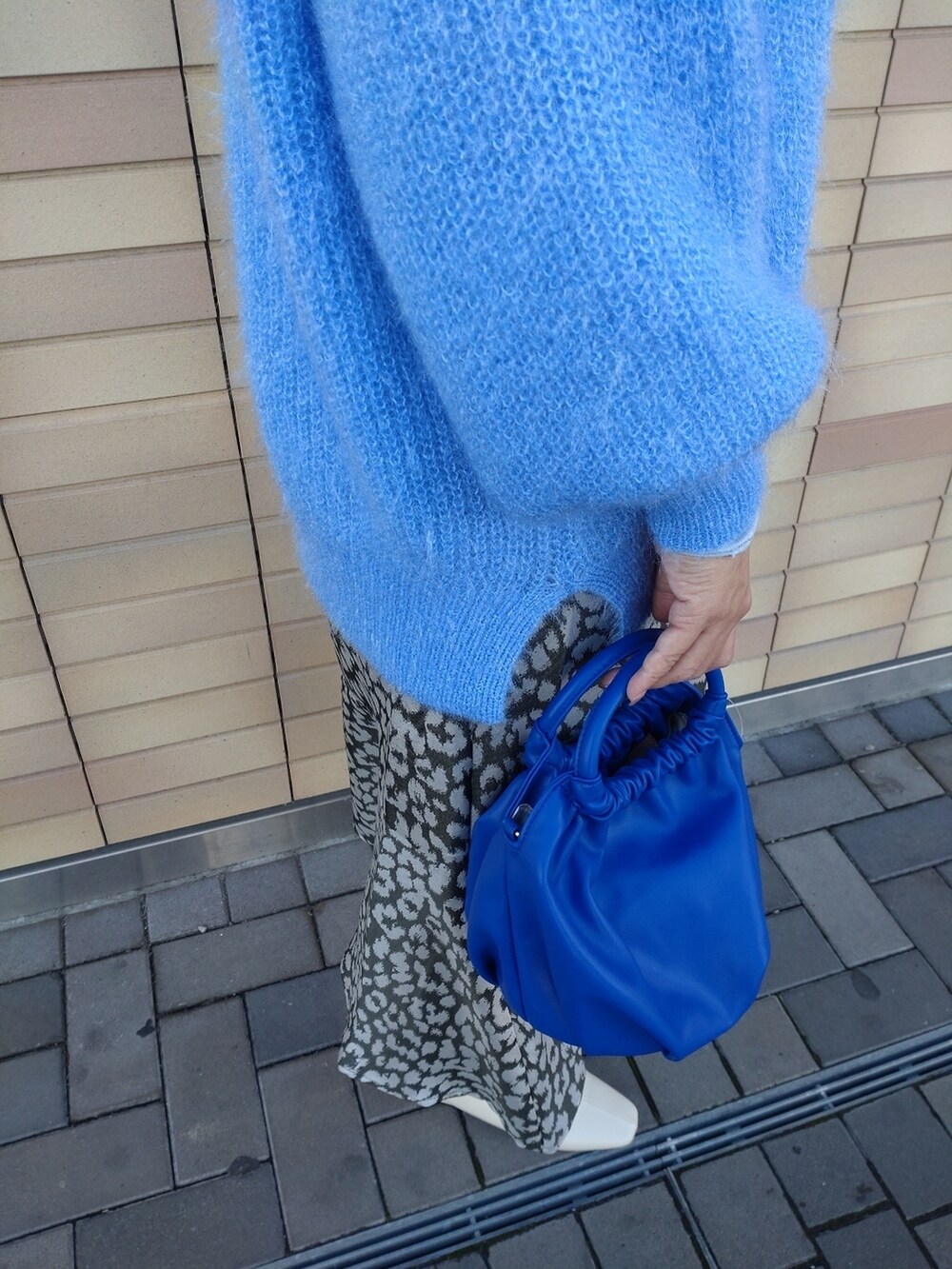 ブルー系のニット/セーター、ホワイト系のブーツ、グリーン系のスカートを着用したレディースの冬コーディネートの5枚目の写真