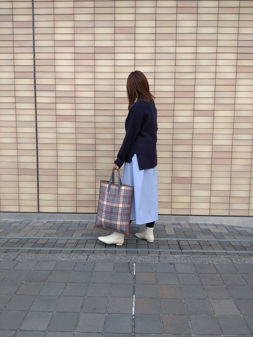 ブルー系のニット/セーター、ベージュ系のショルダーバッグ、ブルー系のスカートを着用したレディースの冬コーディネートの3枚目の写真