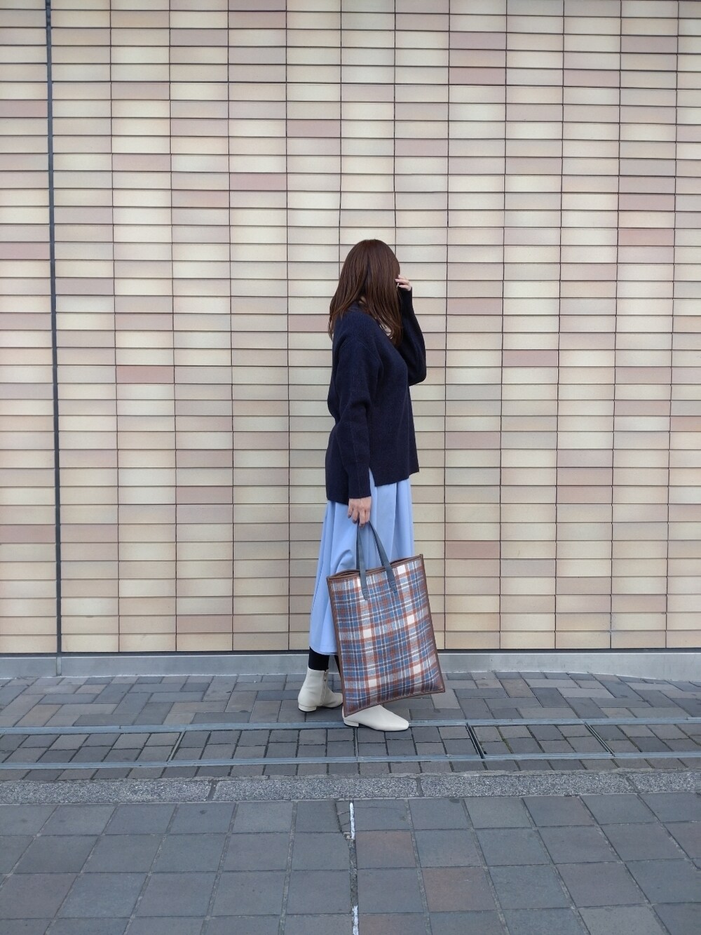 ブルー系のニット/セーター、ベージュ系のショルダーバッグ、ブルー系のスカートを着用したレディースの冬コーディネートの2枚目の写真