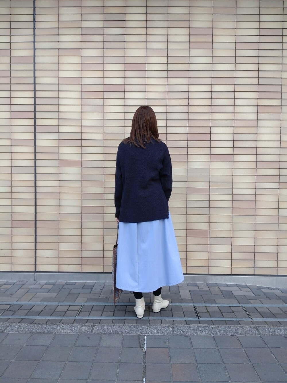 ブルー系のニット/セーター、ベージュ系のショルダーバッグ、ブルー系のスカートを着用したレディースの冬コーディネートの4枚目の写真