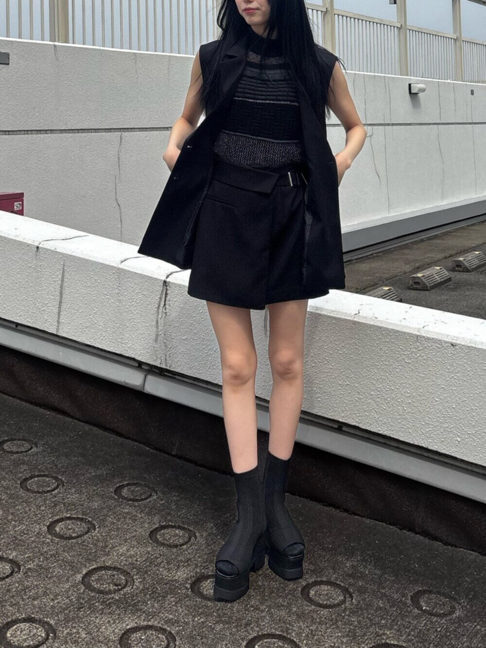 ブラック系のスカート、ブラック系のタンクトップ、ブラック系のベストを着用したレディースの春コーディネートの8枚目の写真