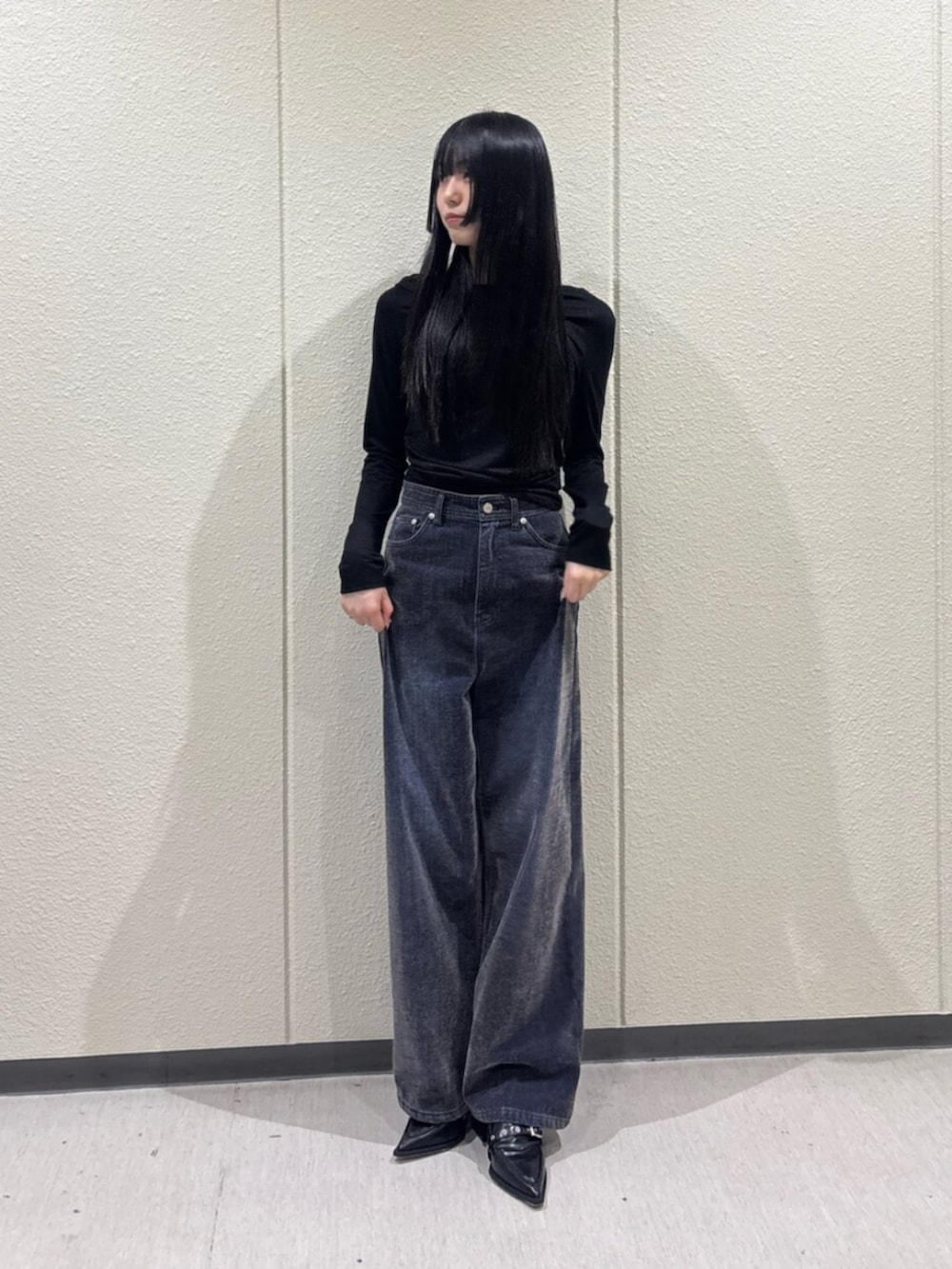 ブラック系のTシャツ/カットソー、ブルー系のデニムパンツ、ブラック系のパンプスを着用したレディースの秋コーディネートの2枚目の写真