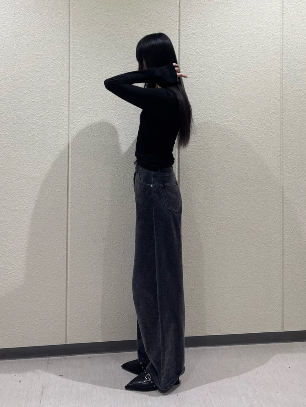 ブラック系のTシャツ/カットソー、ブルー系のデニムパンツ、ブラック系のパンプスを着用したレディースの秋コーディネートの3枚目の写真