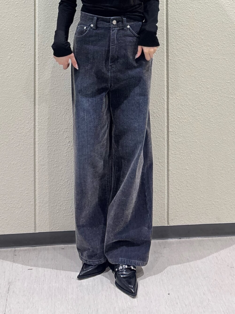 ブラック系のTシャツ/カットソー、ブルー系のデニムパンツ、ブラック系のパンプスを着用したレディースの秋コーディネートの6枚目の写真