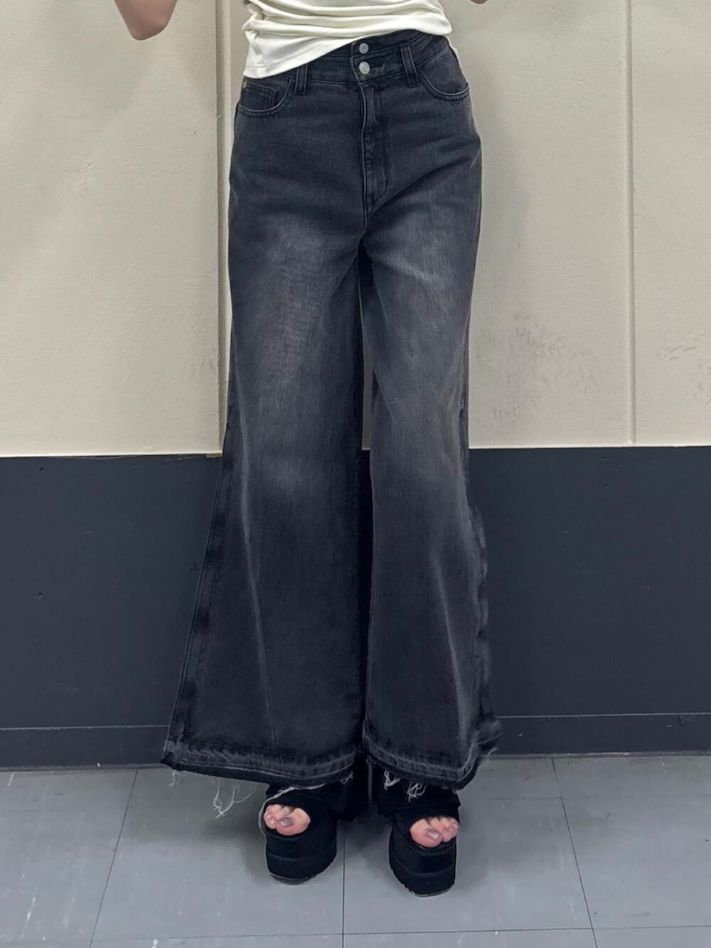 ホワイト系のTシャツ/カットソー、ブラック系のデニムパンツ、ブラック系のブーツを着用したレディースの夏コーディネートの7枚目の写真