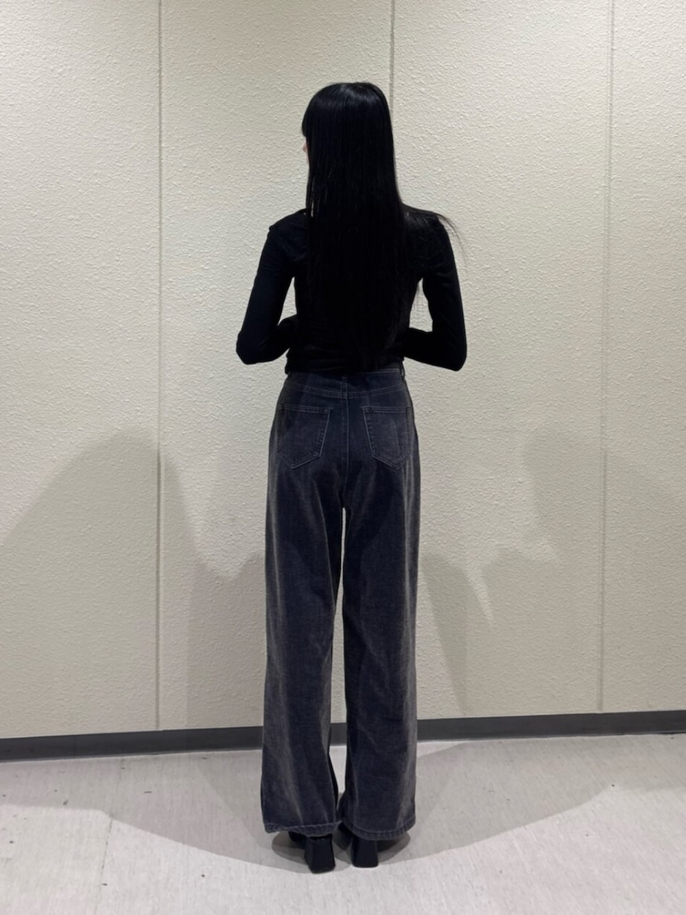 ブラック系のTシャツ/カットソー、ブルー系のデニムパンツ、ブラック系のパンプスを着用したレディースの秋コーディネートの4枚目の写真