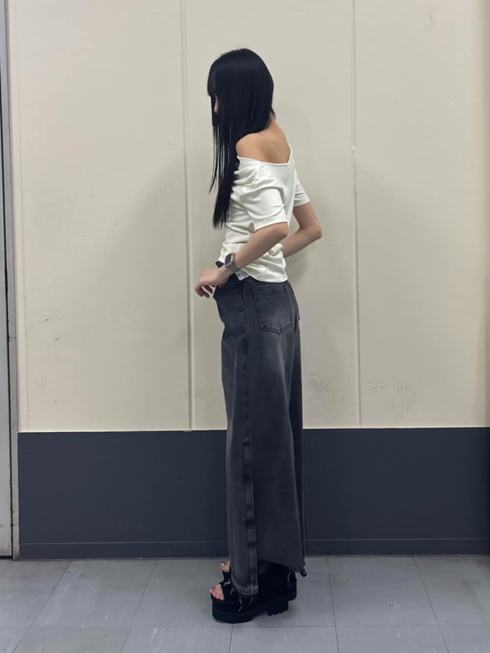 ホワイト系のTシャツ/カットソー、ブラック系のデニムパンツ、ブラック系のブーツを着用したレディースの夏コーディネートの4枚目の写真