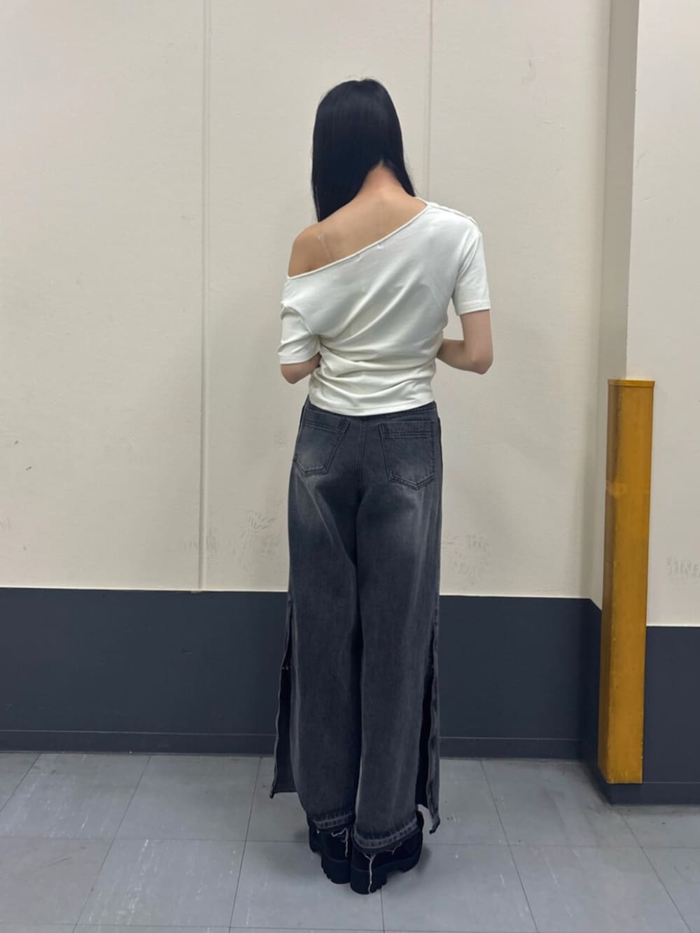 ホワイト系のTシャツ/カットソー、ブラック系のデニムパンツ、ブラック系のブーツを着用したレディースの夏コーディネートの3枚目の写真