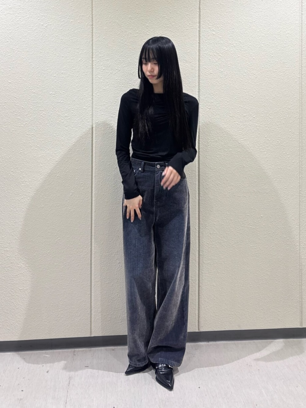 ブラック系のTシャツ/カットソー、ブルー系のデニムパンツ、ブラック系のパンプスを着用したレディースの秋コーディネートの8枚目の写真