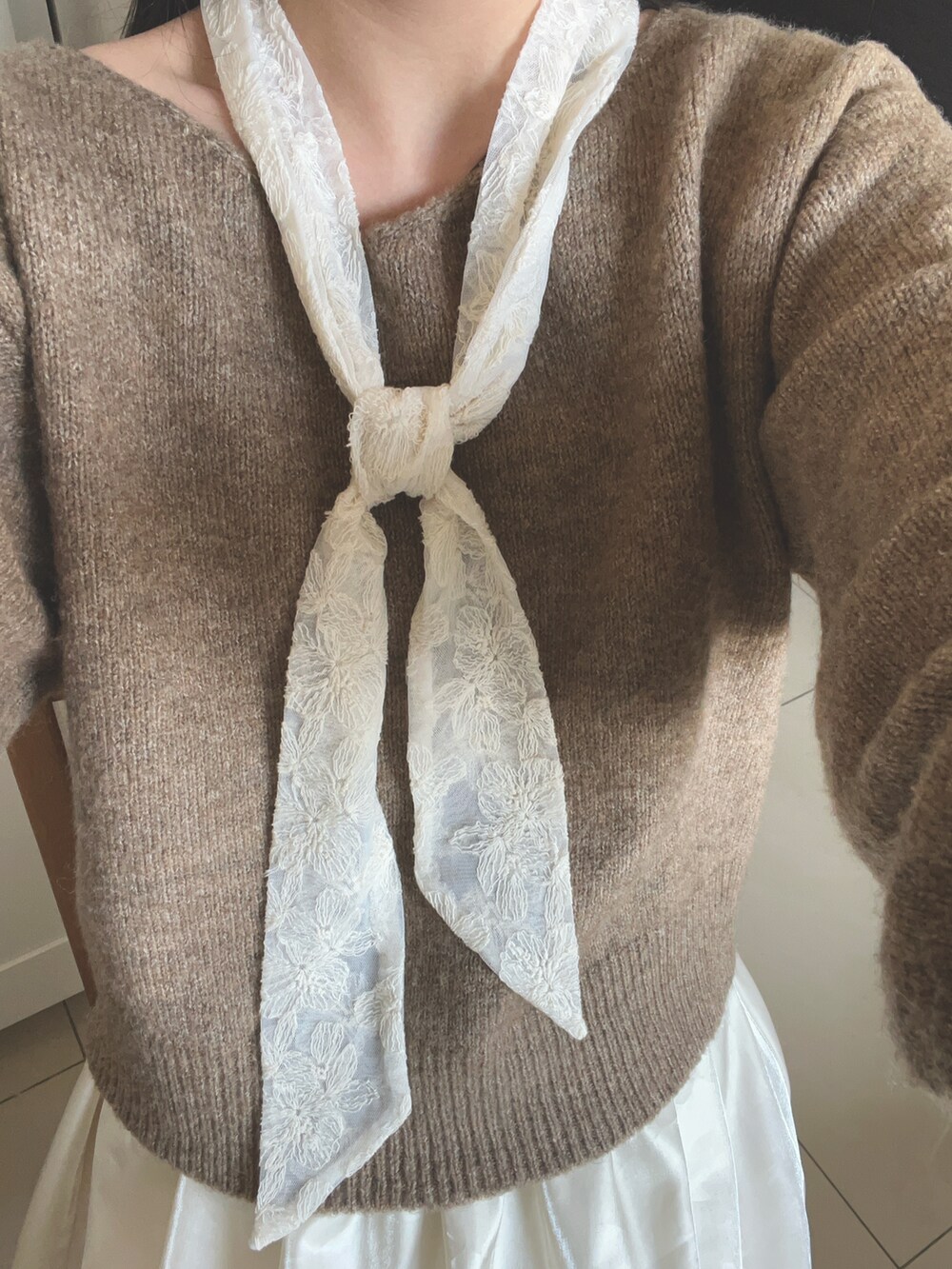 ベージュ系のニット/セーター、ベージュ系のスカート、ホワイト系の付け襟を着用したレディースの春コーディネートの2枚目の写真