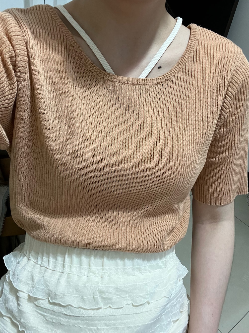 オレンジ系のTシャツ/カットソー、ホワイト系のスカート、ホワイト系のタンクトップを着用したレディースの春コーディネートの4枚目の写真