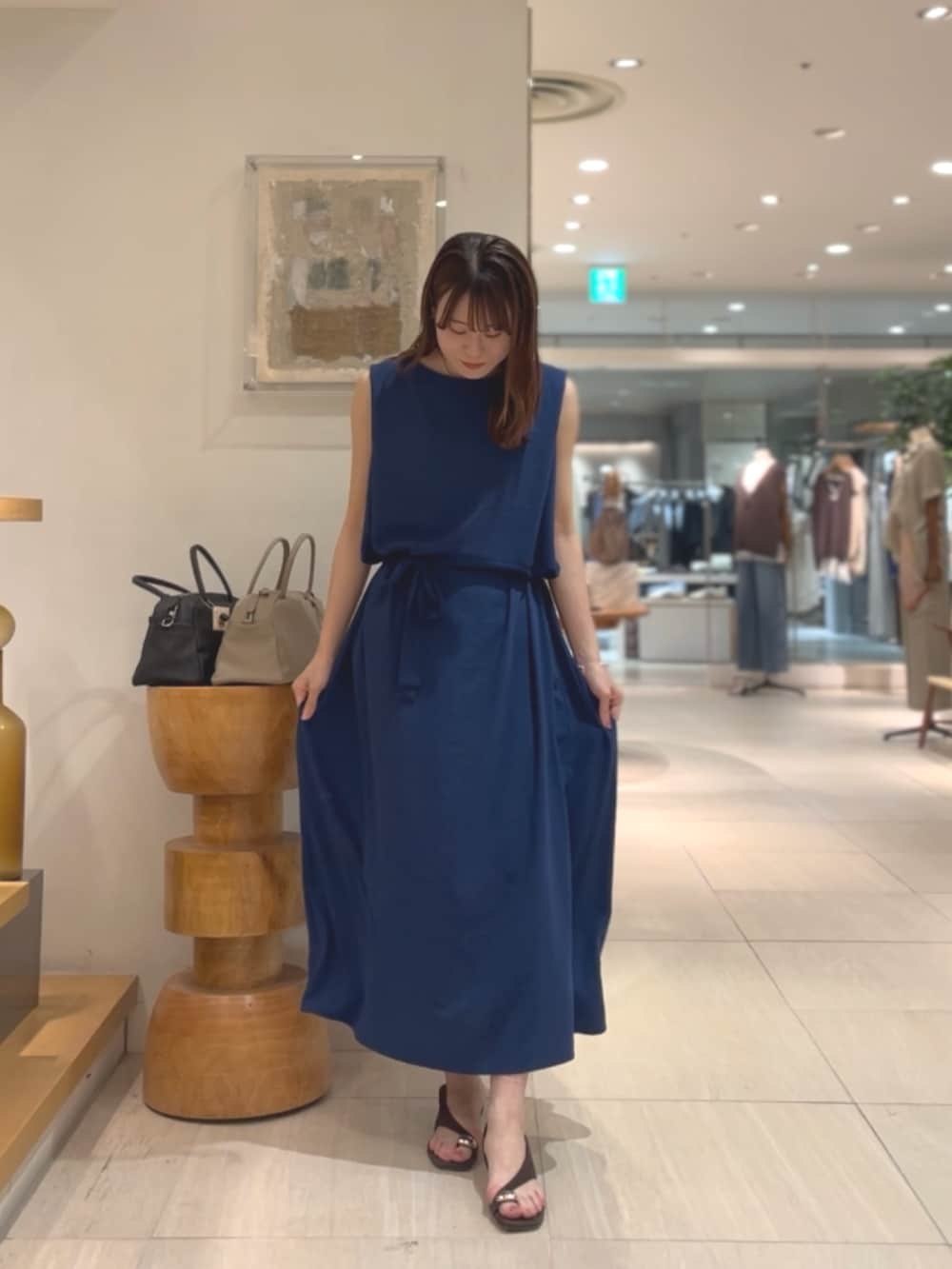 ブルー系のワンピース、ブラウン系のサンダル、シルバー系のネックレスを着用したレディースの夏コーディネートの5枚目の写真