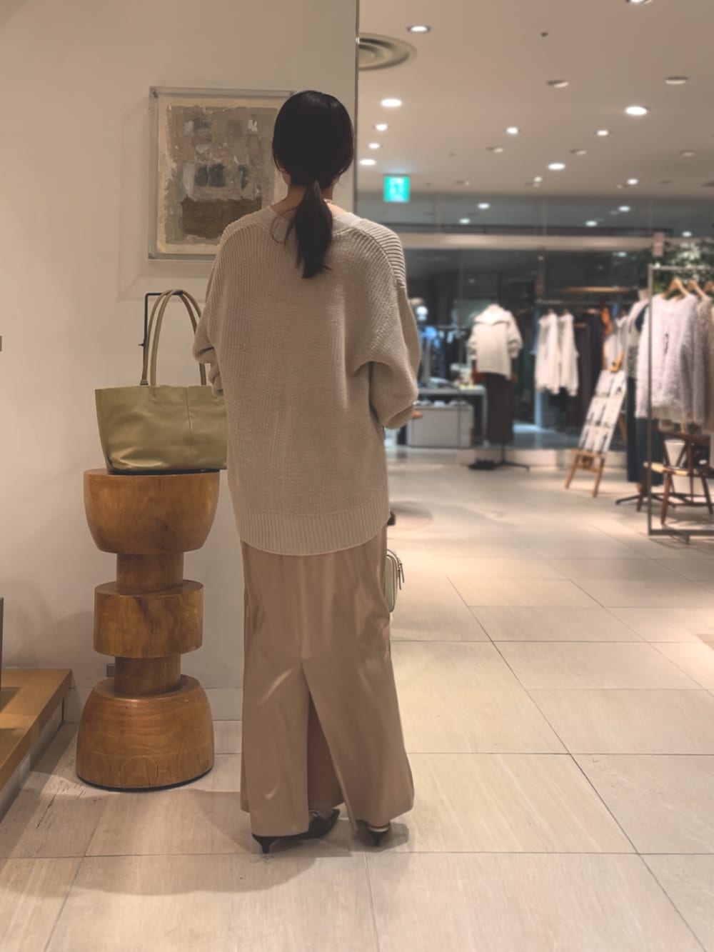ベージュ系のニット/セーター、ホワイト系のスカート、ブラウン系のパンプスを着用したレディースの冬コーディネートの3枚目の写真