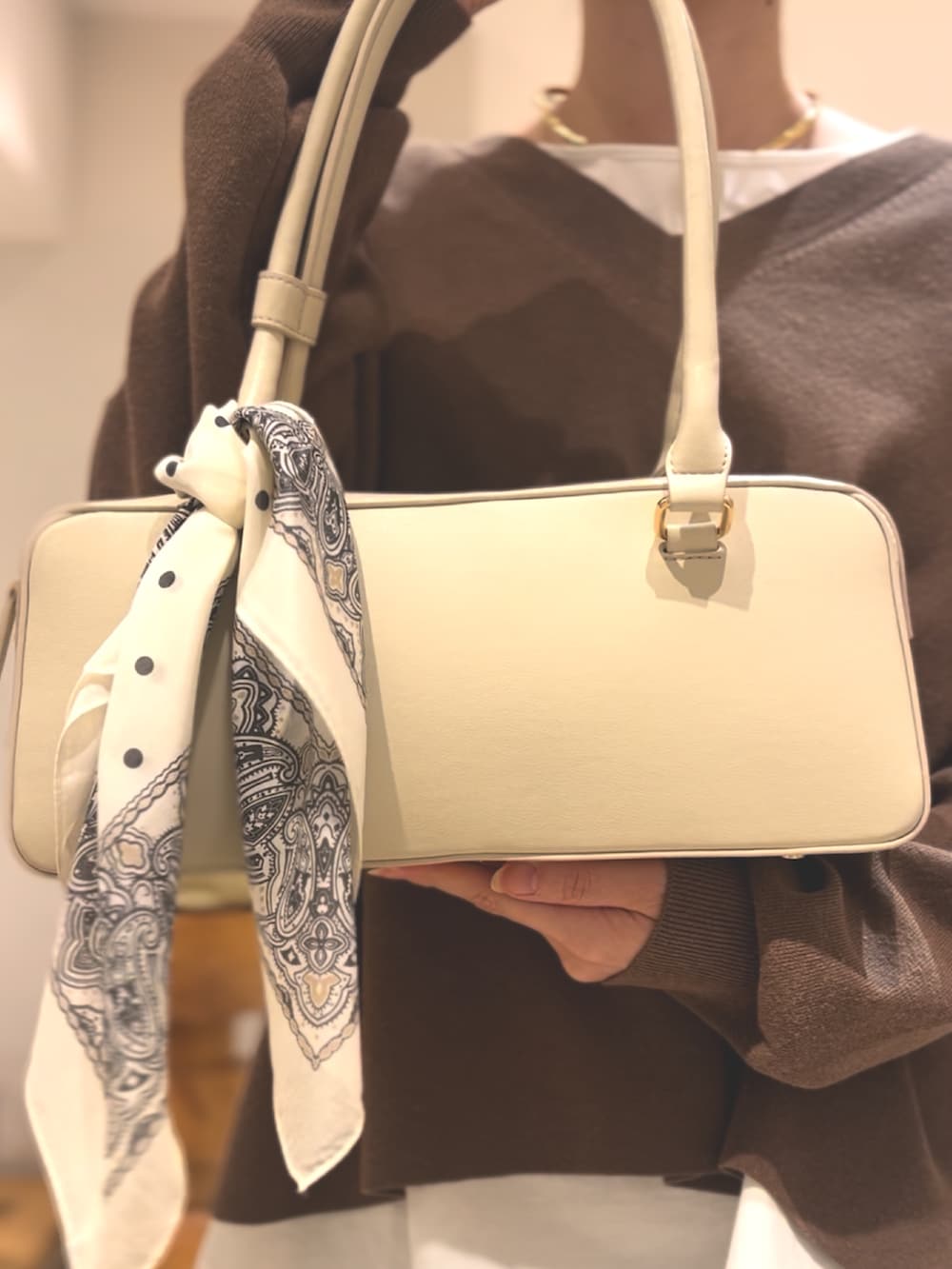 ベージュ系のニット/セーター、ホワイト系のスカート、ブラウン系のパンプスを着用したレディースの冬コーディネートの4枚目の写真