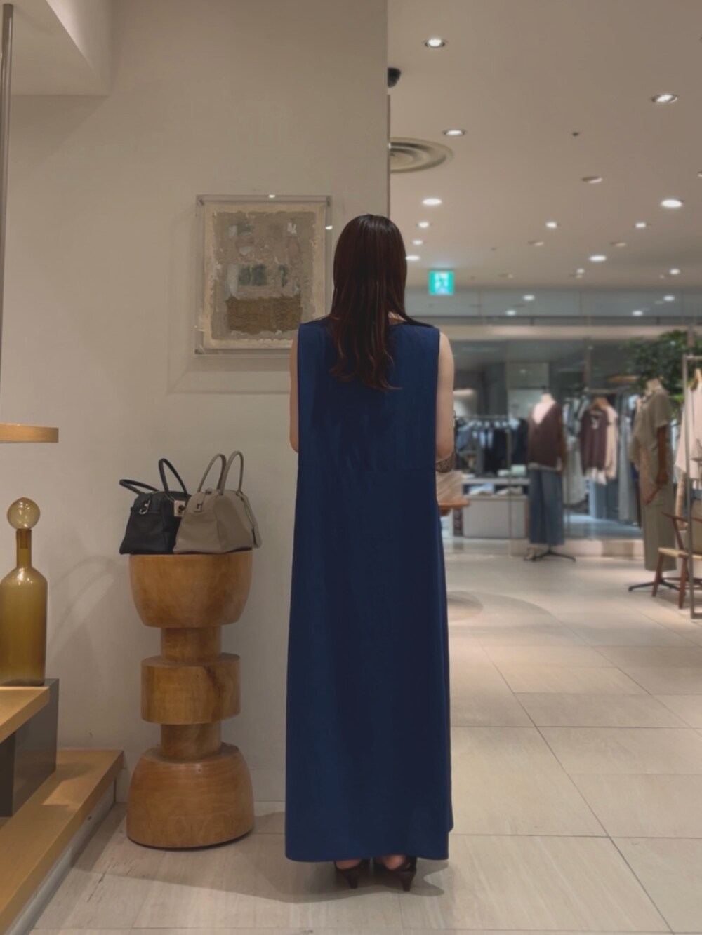 ブルー系のワンピース、ブラウン系のサンダル、シルバー系のネックレスを着用したレディースの夏コーディネートの3枚目の写真