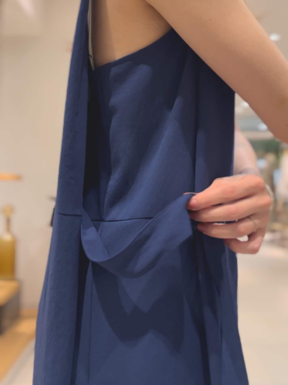 ブルー系のワンピース、ブラウン系のサンダル、シルバー系のネックレスを着用したレディースの夏コーディネートの4枚目の写真