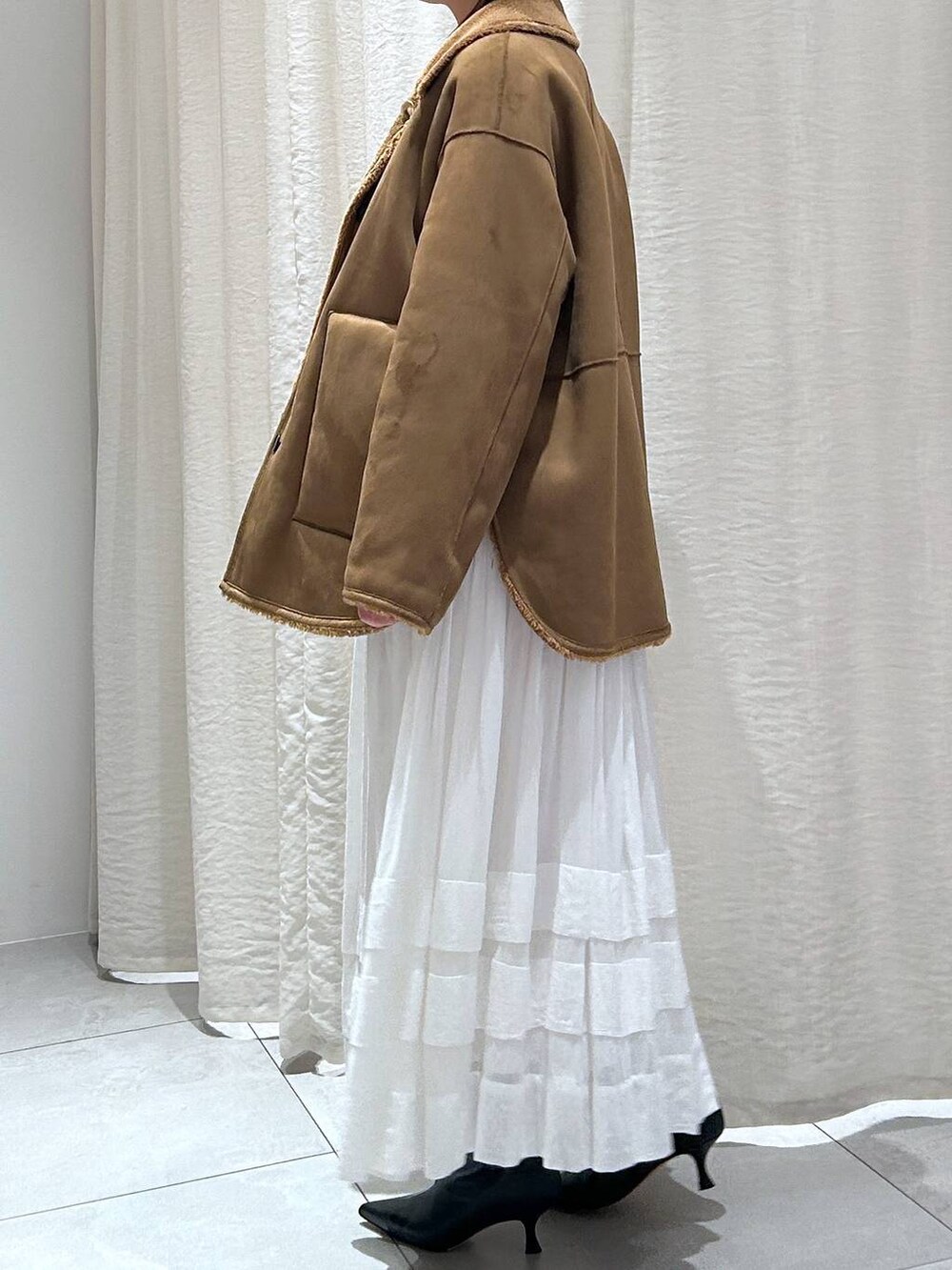 ホワイト系のニット/セーター、ホワイト系のスカート、イエロー系のブルゾンを着用したレディースの秋コーディネートの4枚目の写真