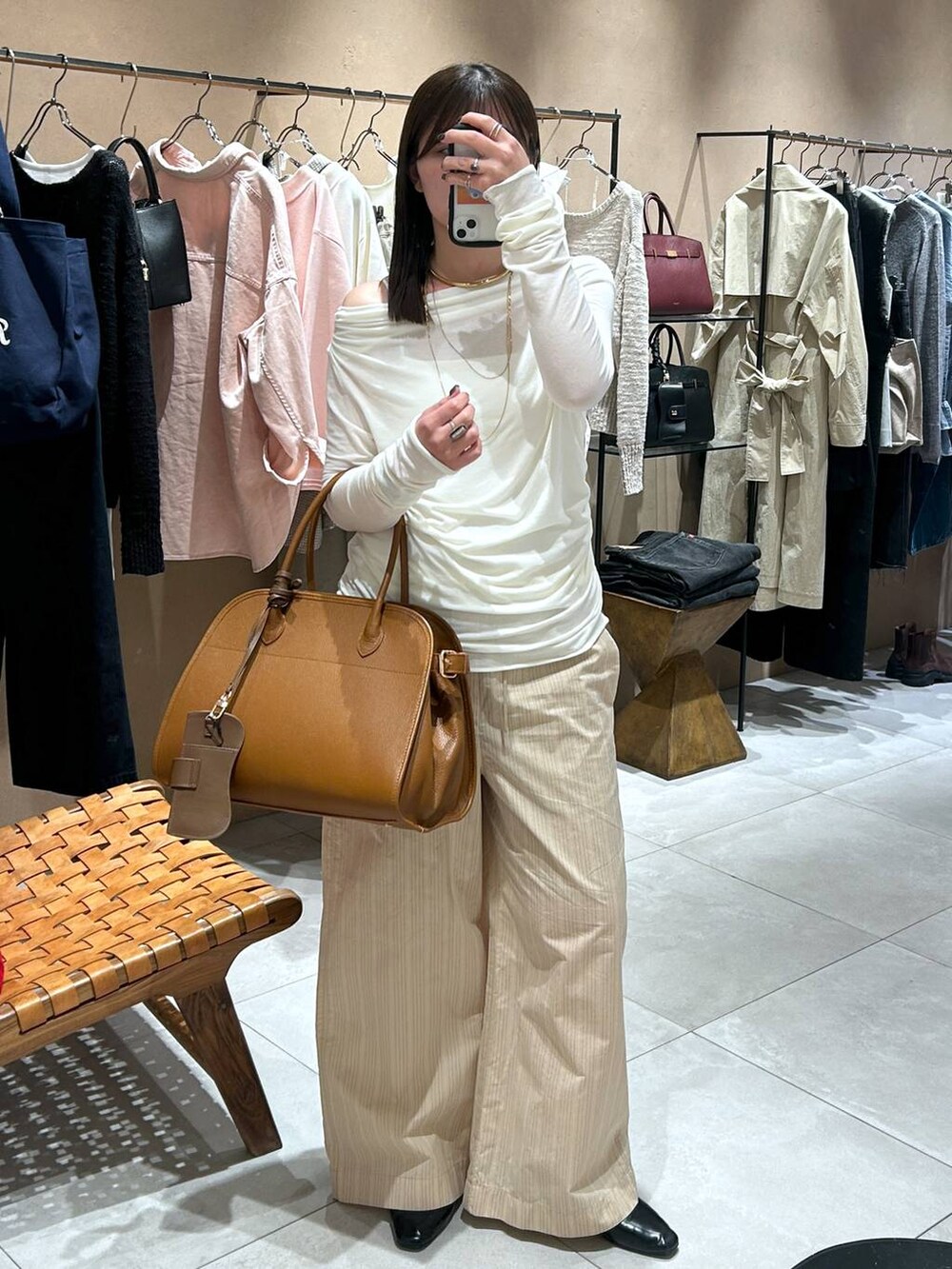 ホワイト系のTシャツ/カットソー、ブラウン系のボストンバッグ、ベージュ系のその他パンツを着用したレディースの冬コーディネートの7枚目の写真