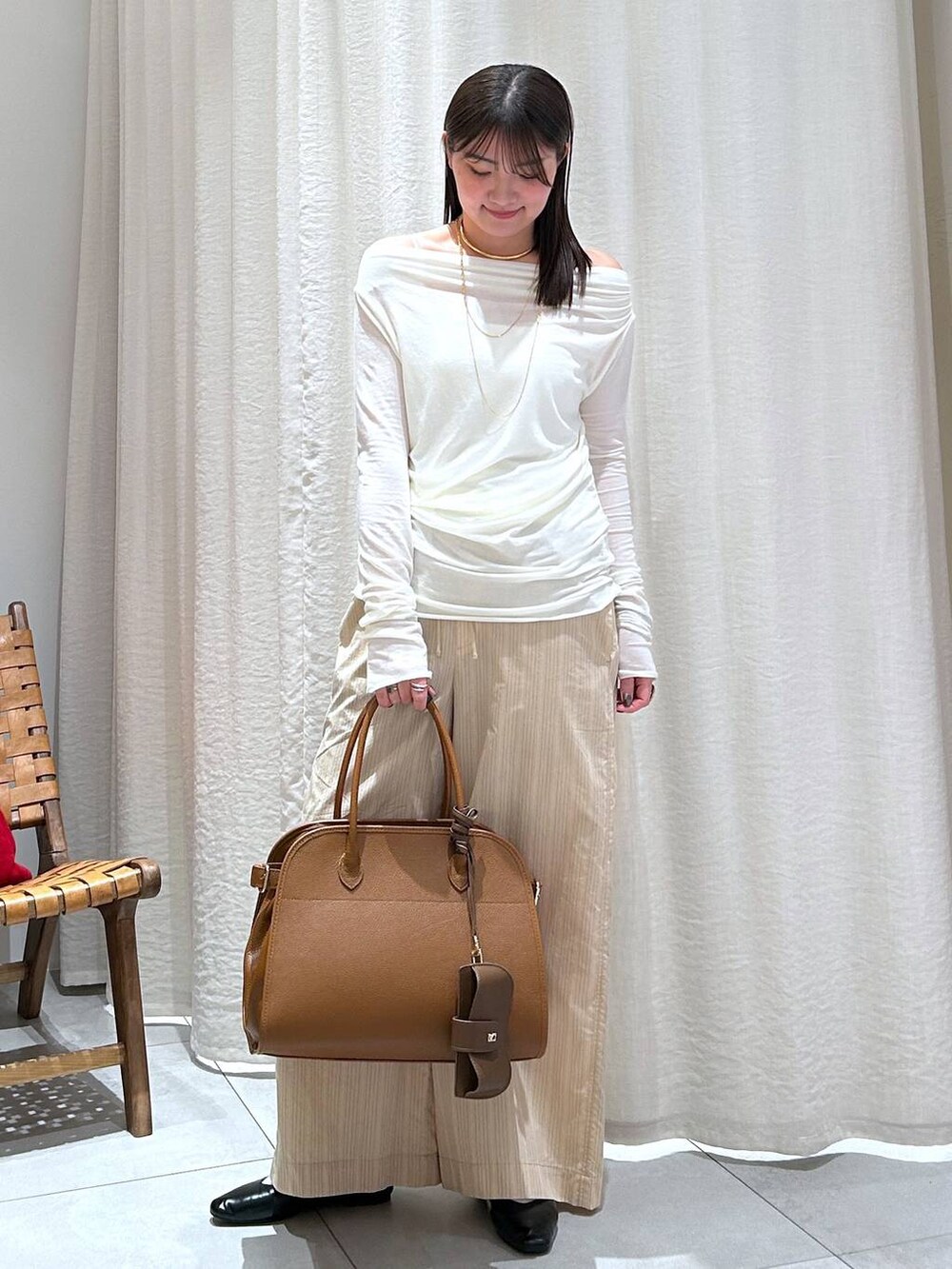ホワイト系のTシャツ/カットソー、ブラウン系のボストンバッグ、ベージュ系のその他パンツを着用したレディースの冬コーディネートの2枚目の写真