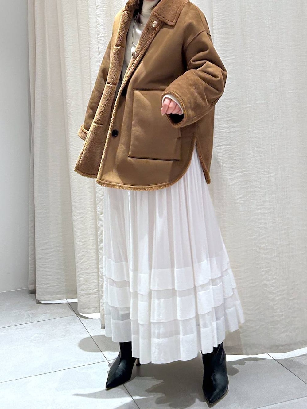 ホワイト系のニット/セーター、ホワイト系のスカート、イエロー系のブルゾンを着用したレディースの秋コーディネートの2枚目の写真