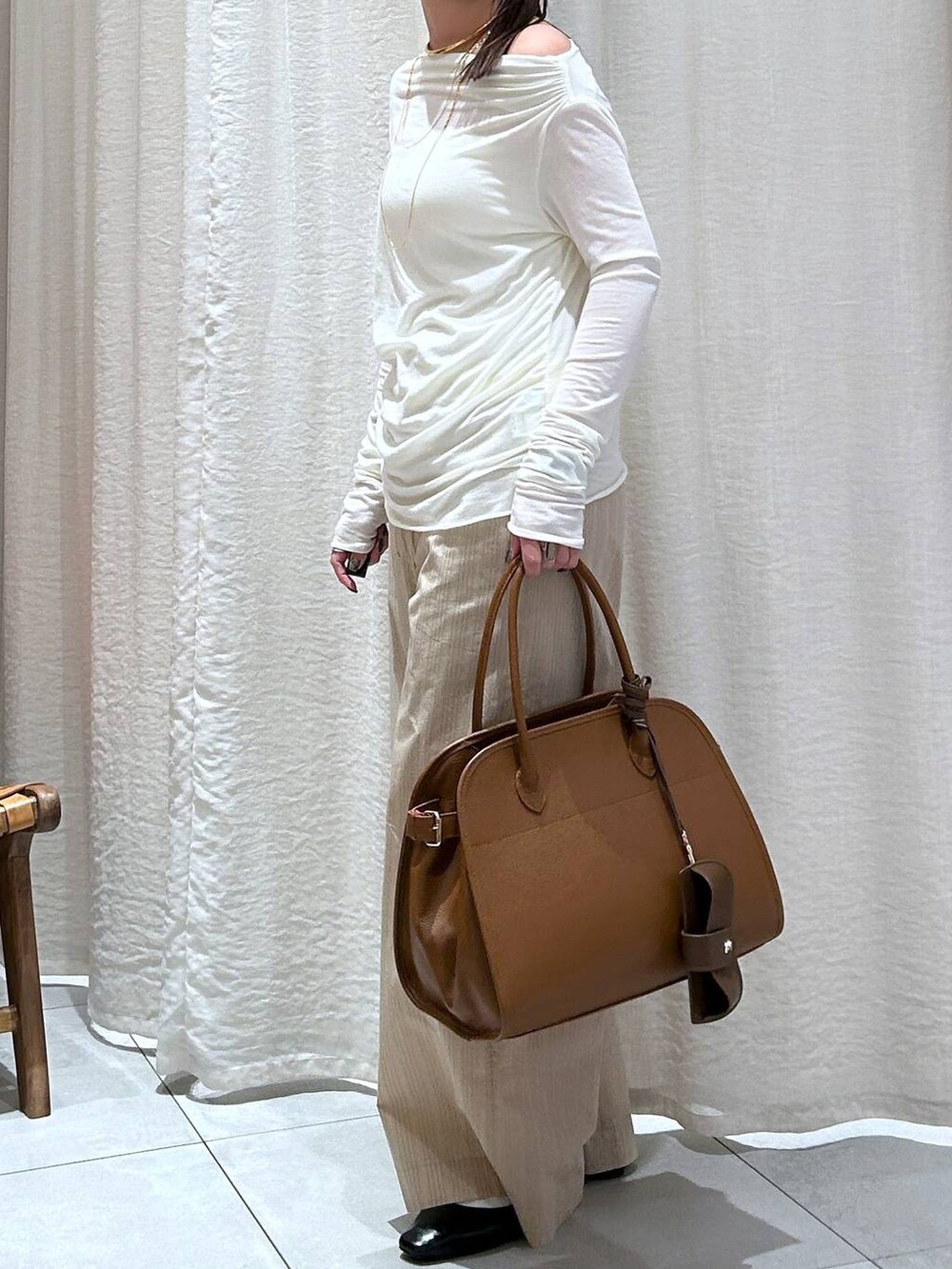 ホワイト系のTシャツ/カットソー、ブラウン系のボストンバッグ、ベージュ系のその他パンツを着用したレディースの冬コーディネートの5枚目の写真