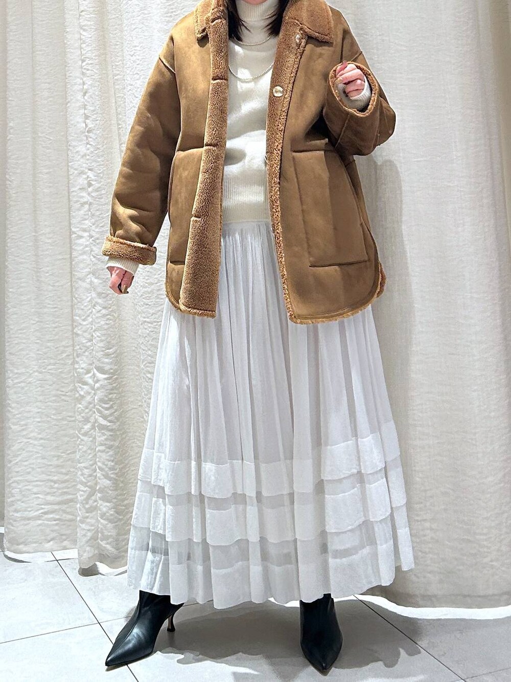 ホワイト系のニット/セーター、ホワイト系のスカート、イエロー系のブルゾンを着用したレディースの秋コーディネートの7枚目の写真