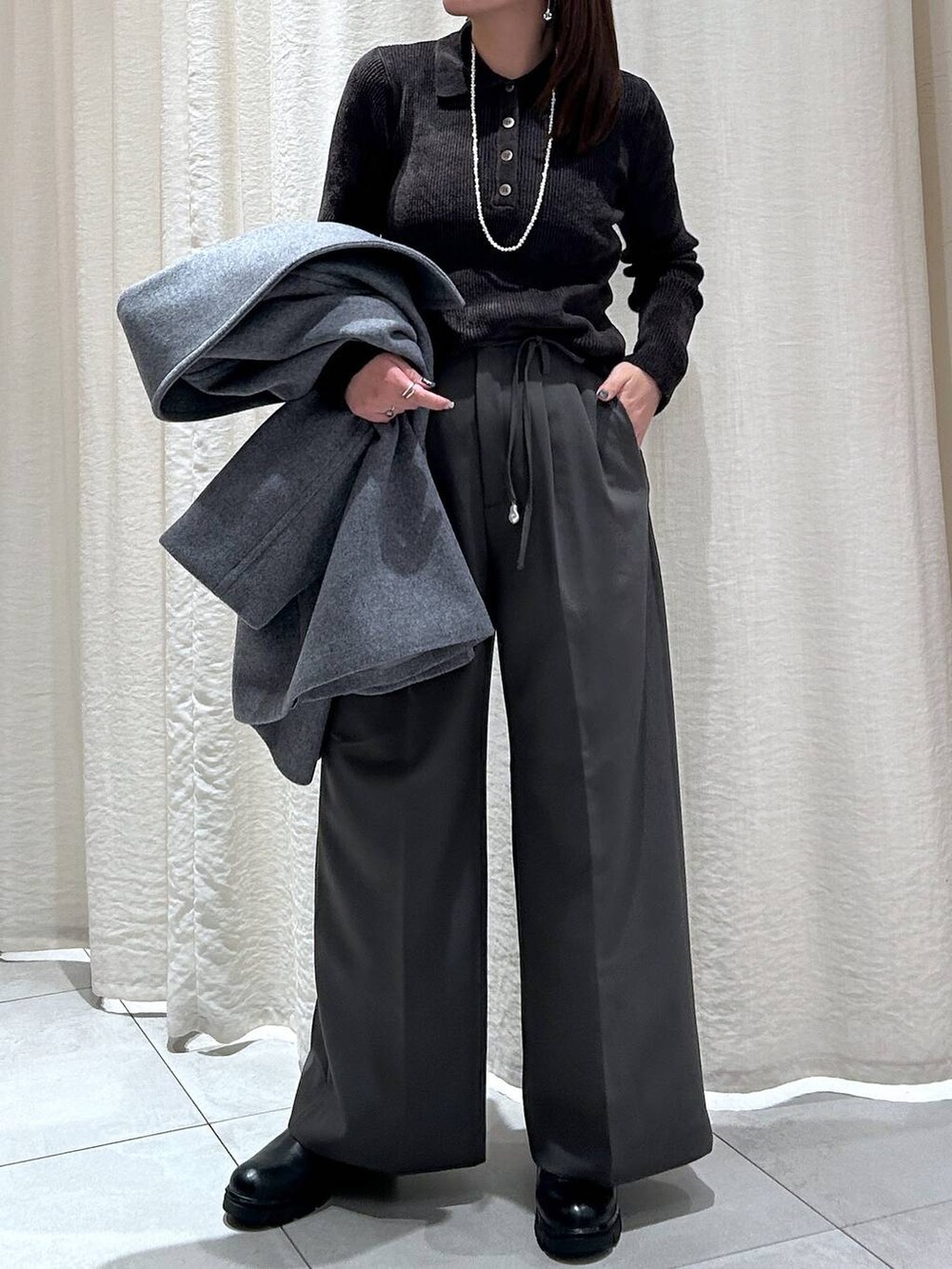 ブラック系のブーツ、グレー系のピーコート、グレー系のその他パンツを着用したレディースの冬コーディネートの2枚目の写真