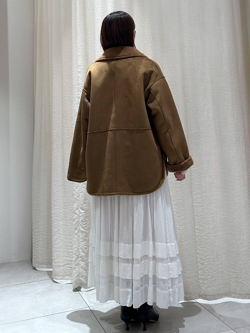 ホワイト系のニット/セーター、ホワイト系のスカート、イエロー系のブルゾンを着用したレディースの秋コーディネートの5枚目の写真