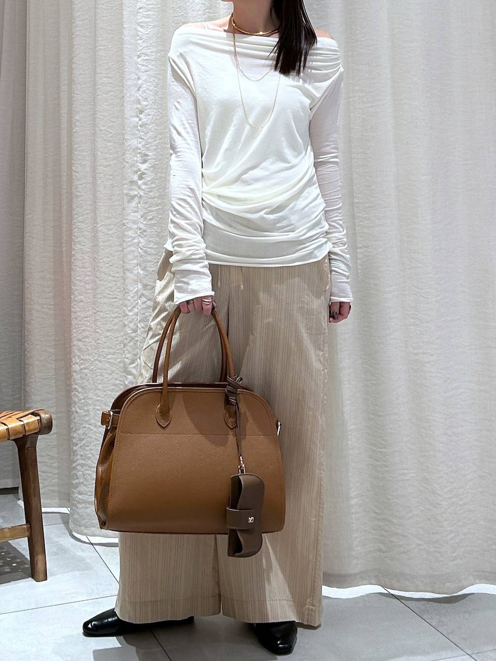 ホワイト系のTシャツ/カットソー、ブラウン系のボストンバッグ、ベージュ系のその他パンツを着用したレディースの冬コーディネートの3枚目の写真