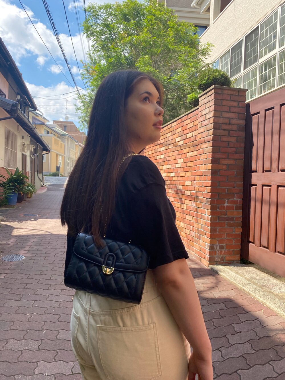 ブラック系のショルダーバッグ、ブラック系のTシャツ/カットソー、ベージュ系のその他パンツを着用したレディースの冬コーディネートの3枚目の写真