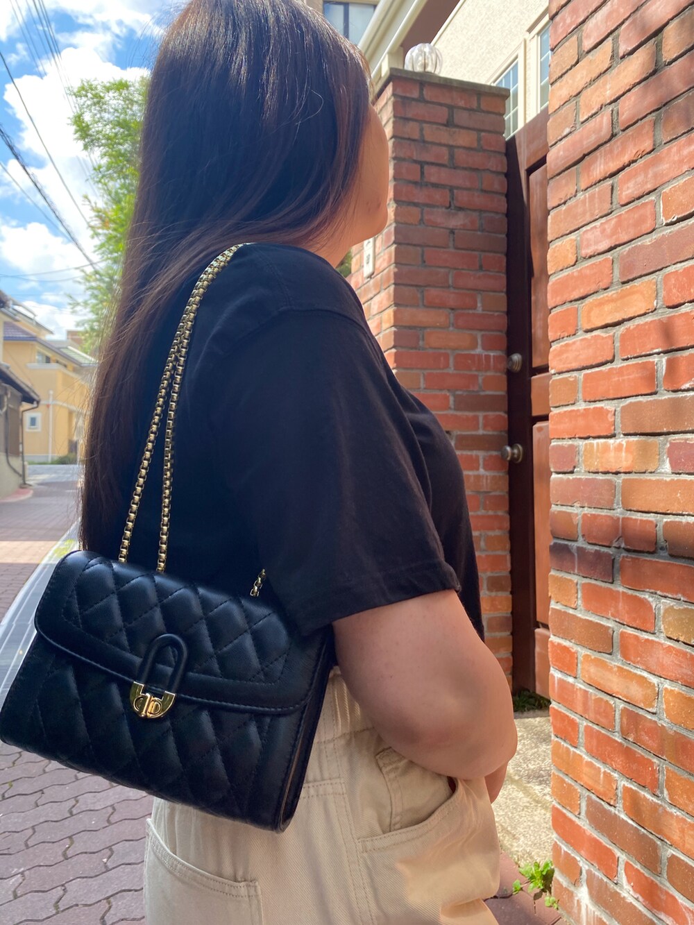 ブラック系のショルダーバッグ、ブラック系のTシャツ/カットソー、ベージュ系のその他パンツを着用したレディースの冬コーディネートの4枚目の写真