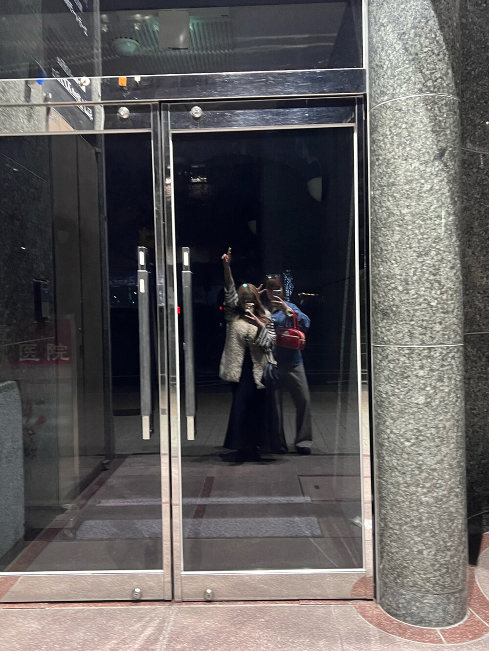 ホワイト系のトップス、ブラック系のショルダーバッグ、ブラック系のスカートを着用したレディースの春コーディネートの2枚目の写真