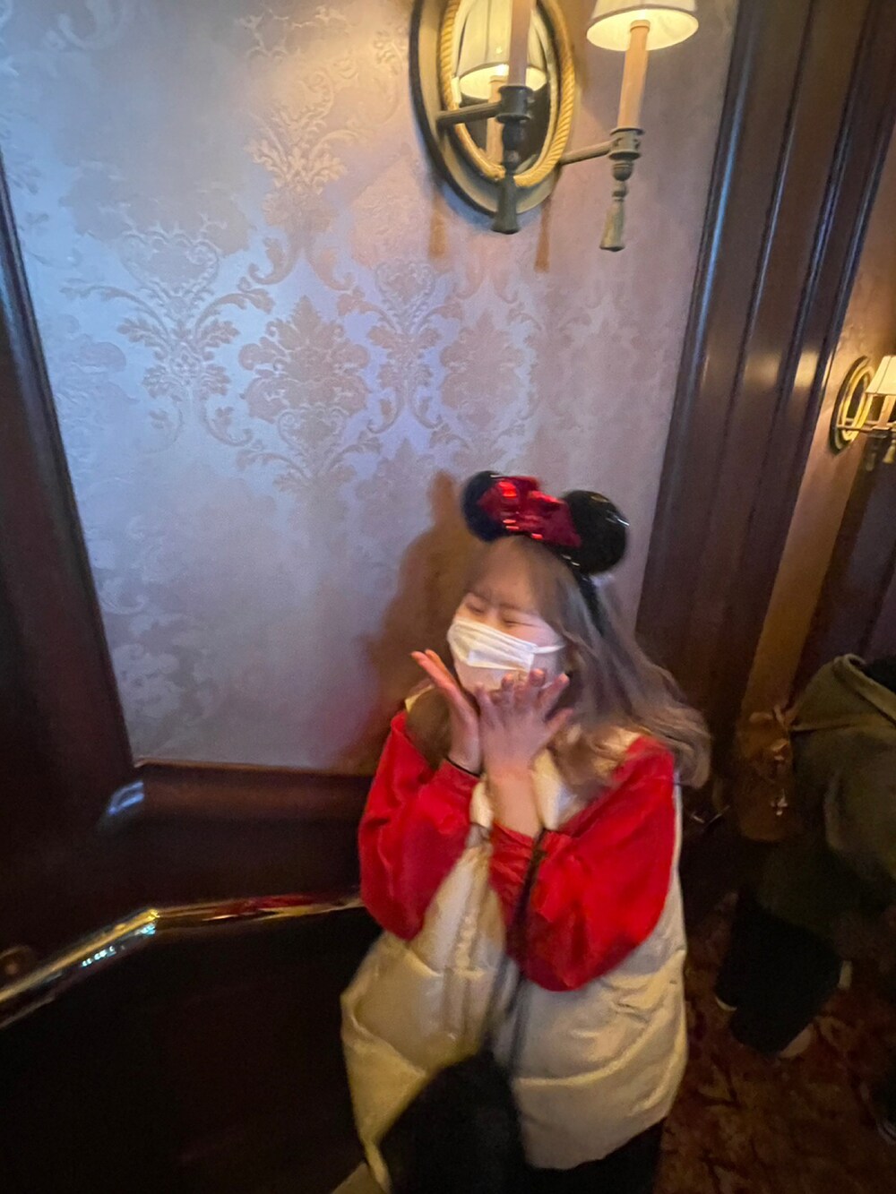 レッド系のスウェット、ブラック系のブーツ、ブラック系のスカートを着用したレディースの春コーディネートの3枚目の写真