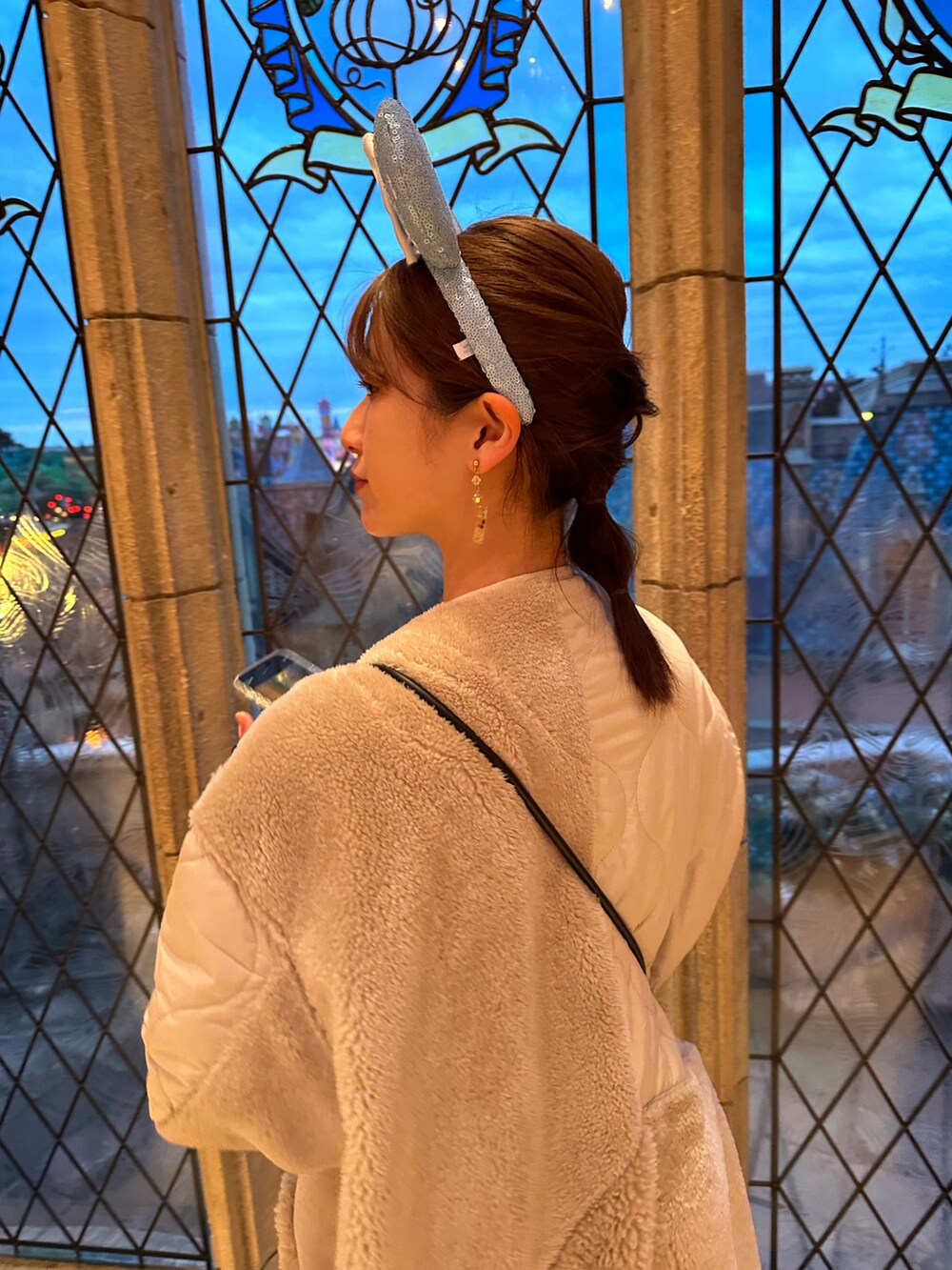 ホワイト系のワンピース、ホワイト系のブーツ、ブルー系のショルダーバッグを着用したレディースの冬コーディネートの3枚目の写真