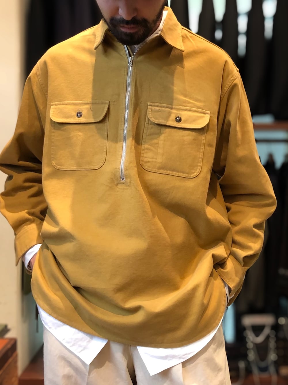 ベージュ系のチノパンツ、ブラウン系のローファー、イエロー系のシャツ/ブラウスを着用したメンズの秋コーディネートの3枚目の写真