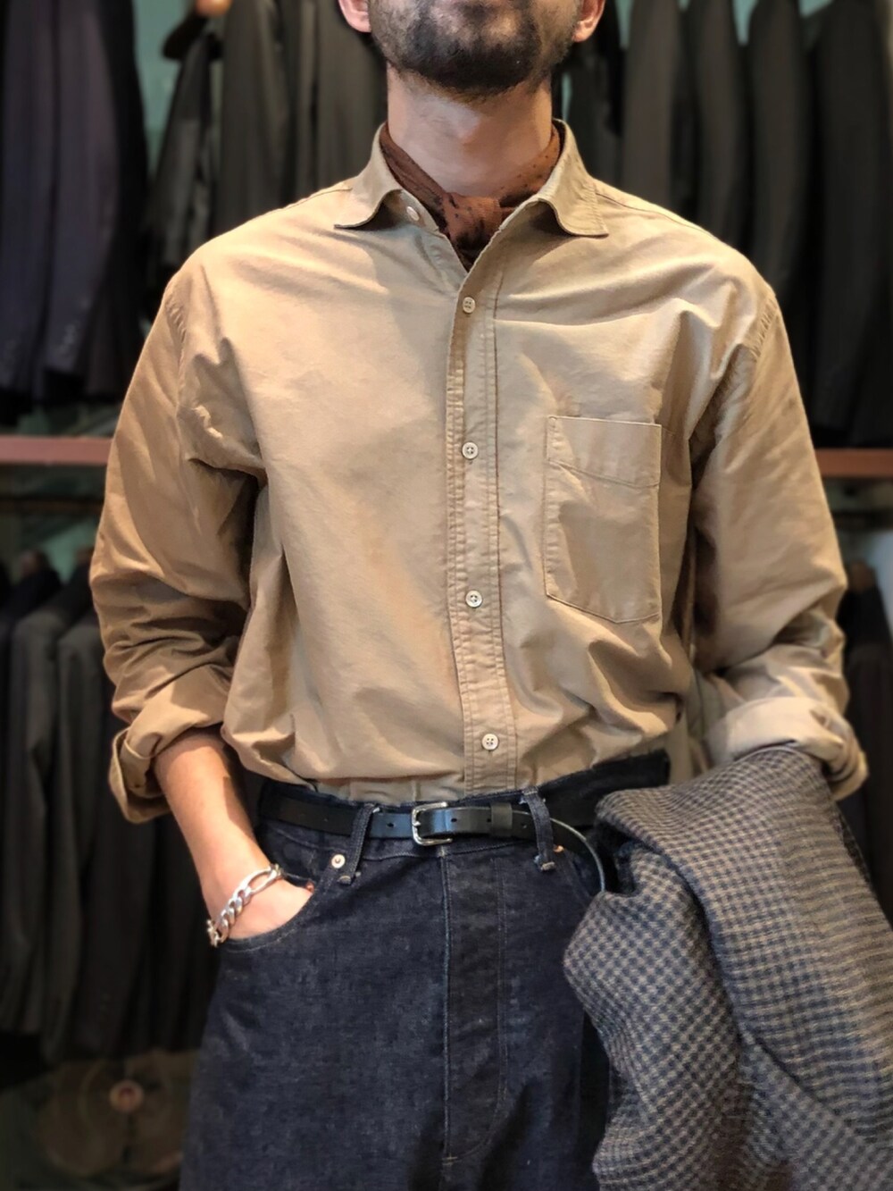 ブルー系のデニムパンツ、ホワイト系のスニーカー、ブラウン系のテーラードジャケットを着用したメンズの秋コーディネートの3枚目の写真