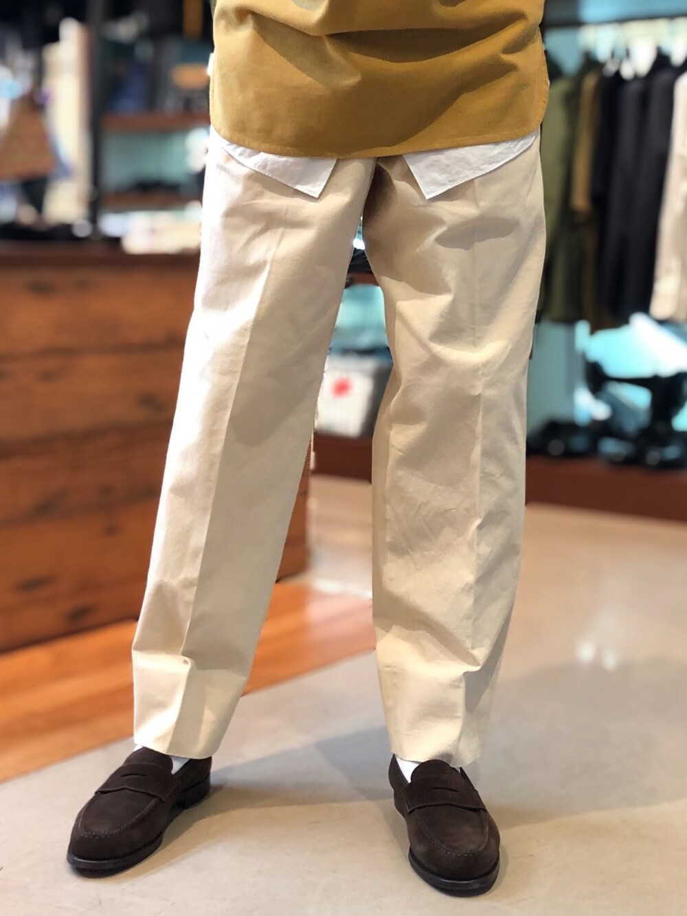 ベージュ系のチノパンツ、ブラウン系のローファー、イエロー系のシャツ/ブラウスを着用したメンズの秋コーディネートの5枚目の写真