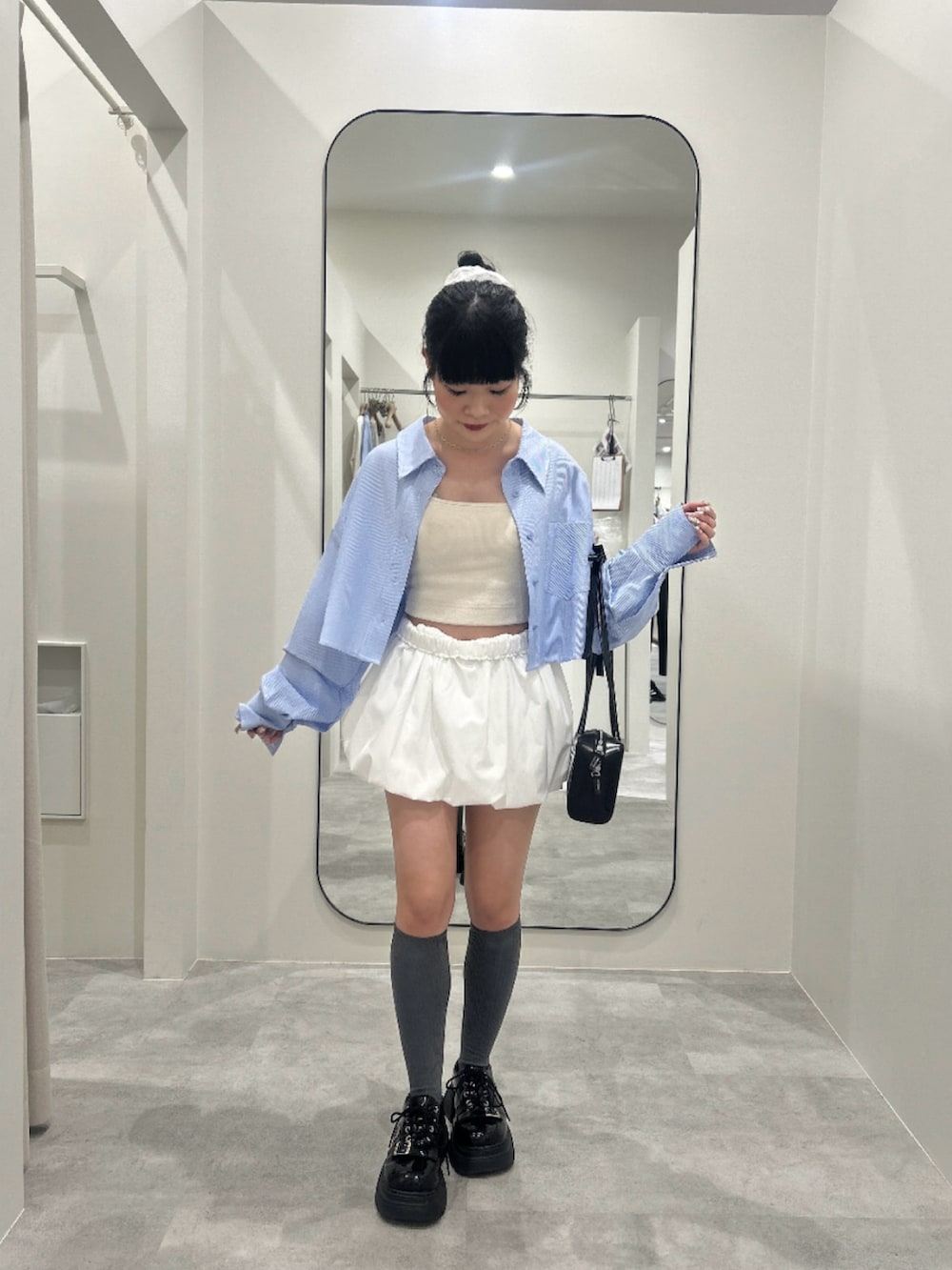 ホワイト系のスカート、ブルー系のシャツ/ブラウスを着用したレディースの春コーディネートの2枚目の写真